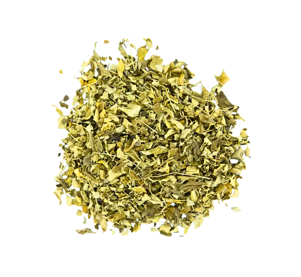 Vue de dessus d'un monticule de petites feuilles séchées de couleur vert olive à jaune-brun, coupées en petits morceaux