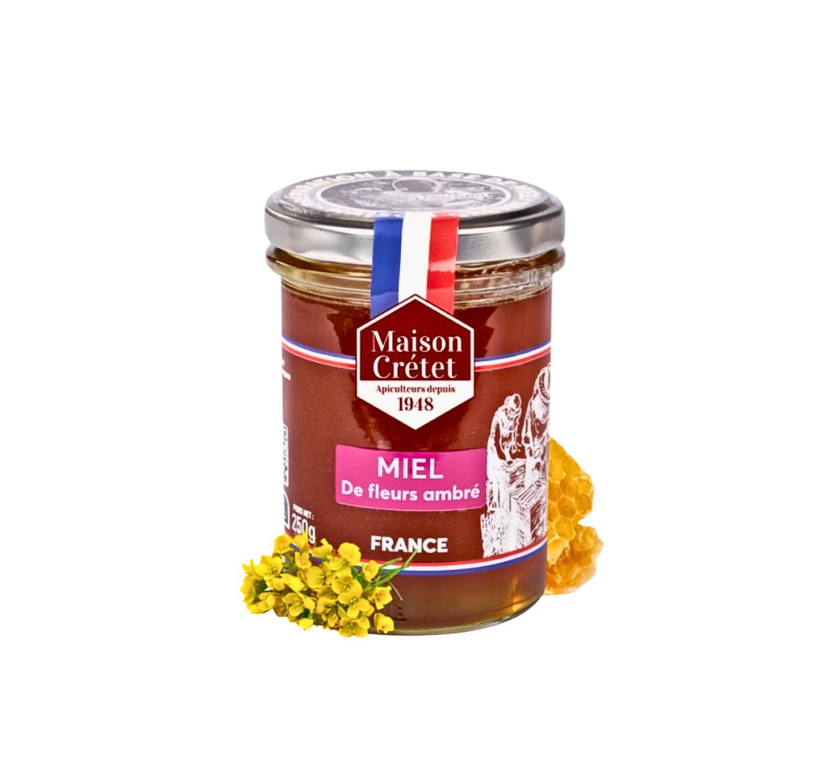 Un pot en verre contenant du miel ambré profond de la marque Maison Crétet . L'étiquette est brun-rouge avec un bandeau rose sur lequel est inscrit « MIEL De fleurs ambré » . Une petite grappe de fleurs jaunes, probablement des fleurs de colza ou de canola, est visible en bas à gauche, et un rayon de miel est visible à droite. 