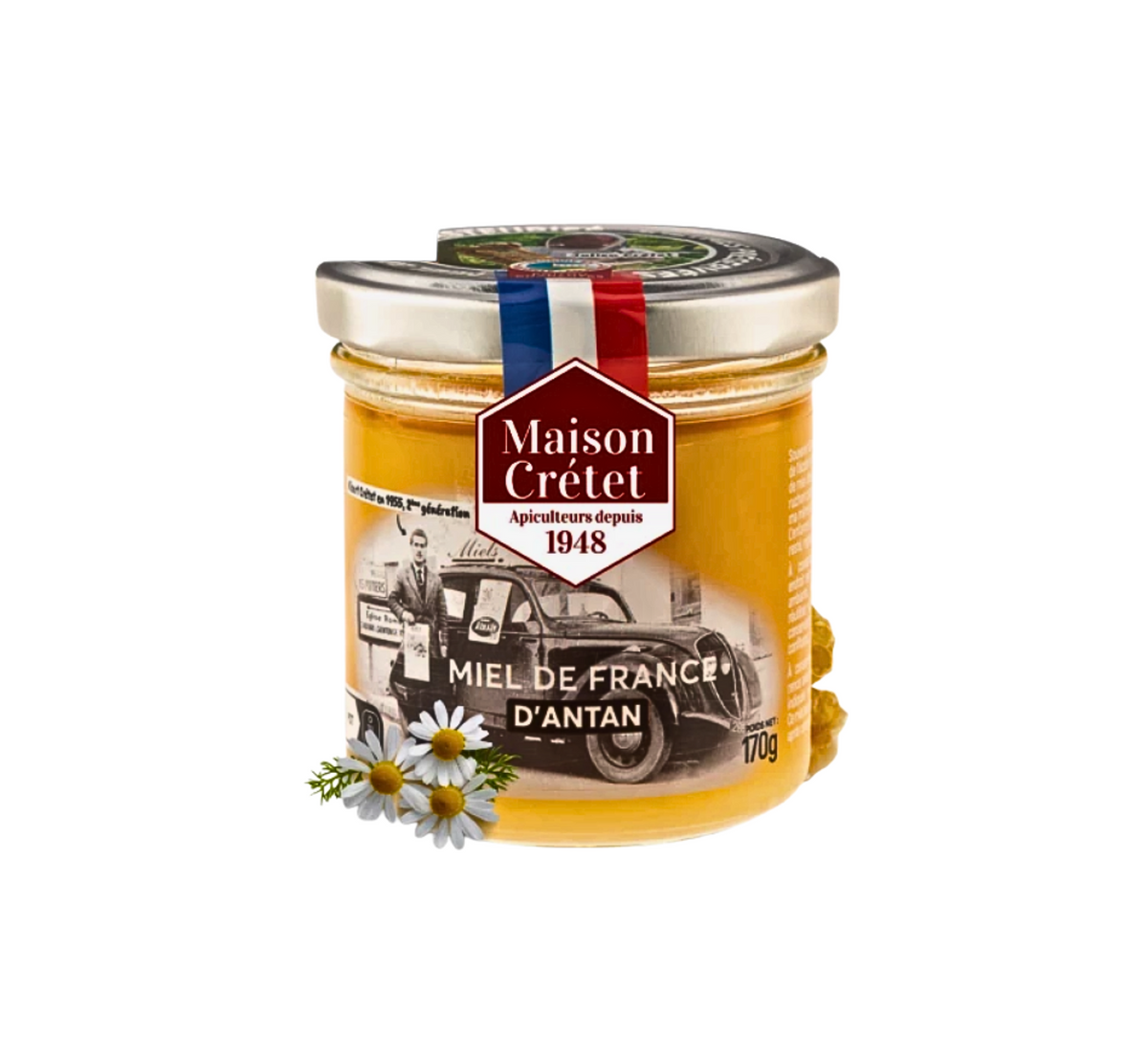 Un pot en verre de miel jaune orangé de la marque Maison Crétet . L'étiquette présente une vieille photo en noir et blanc d'un homme à côté d'une voiture de collection. On peut y lire « Miel de France d'antan » et « Apiculteurs depuis 1948 » 