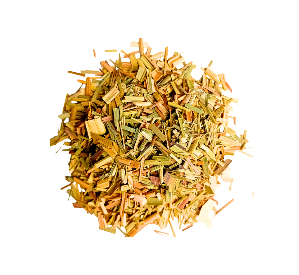 Vue de dessus d'un tas de petits morceaux coupés en fines lanières, de couleur vert-jaune paille, typiques de la citronnelle séchée, isolés sur un fond blanc.