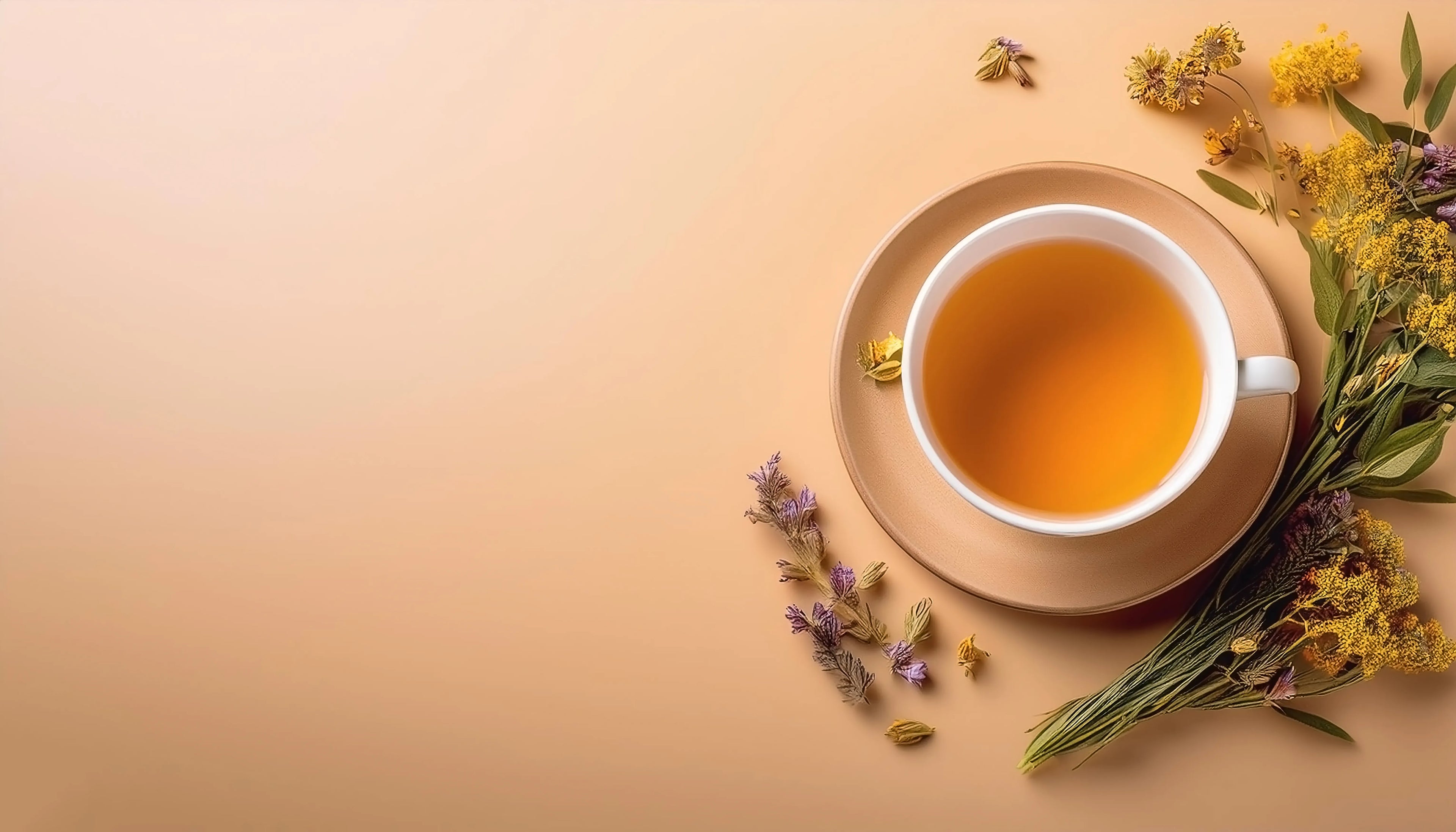 Vue de dessus d'une tasse de thé aux herbes sur une soucoupe, placée sur un fond crème. À côté se trouve un bouquet de fleurs séchées aux tons jaunes et violets.